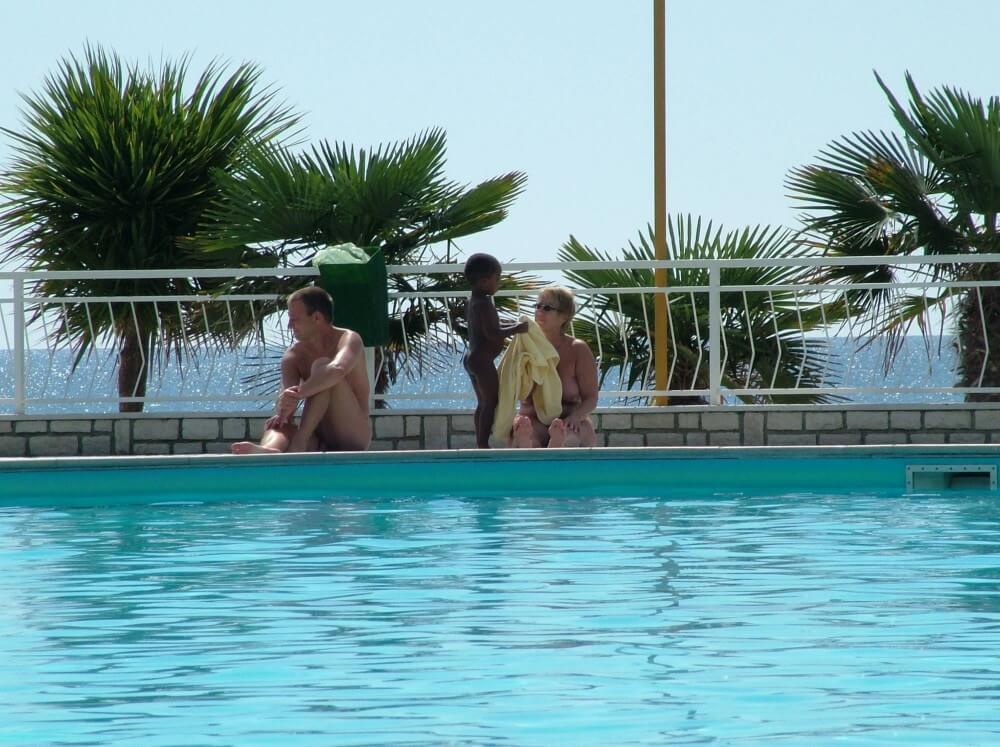 Photo of naturists in an outdoor pool - The idea of freedom and self-acceptance, as embodied by Adam and Eve, is important